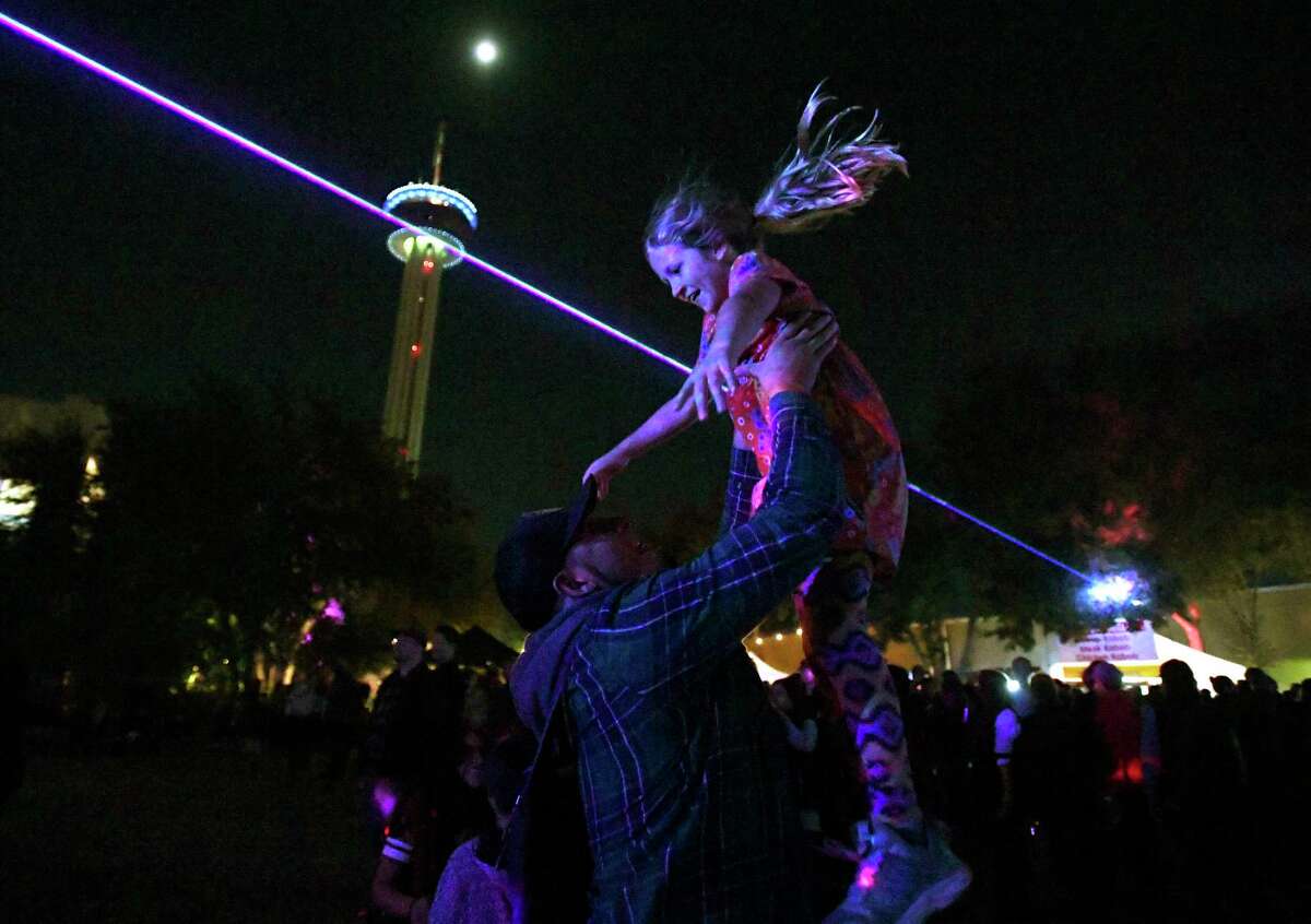 Olivia Barajas is tossed into the air during a laser light show by Hector Celestino de la Cruz during Luminaria.
