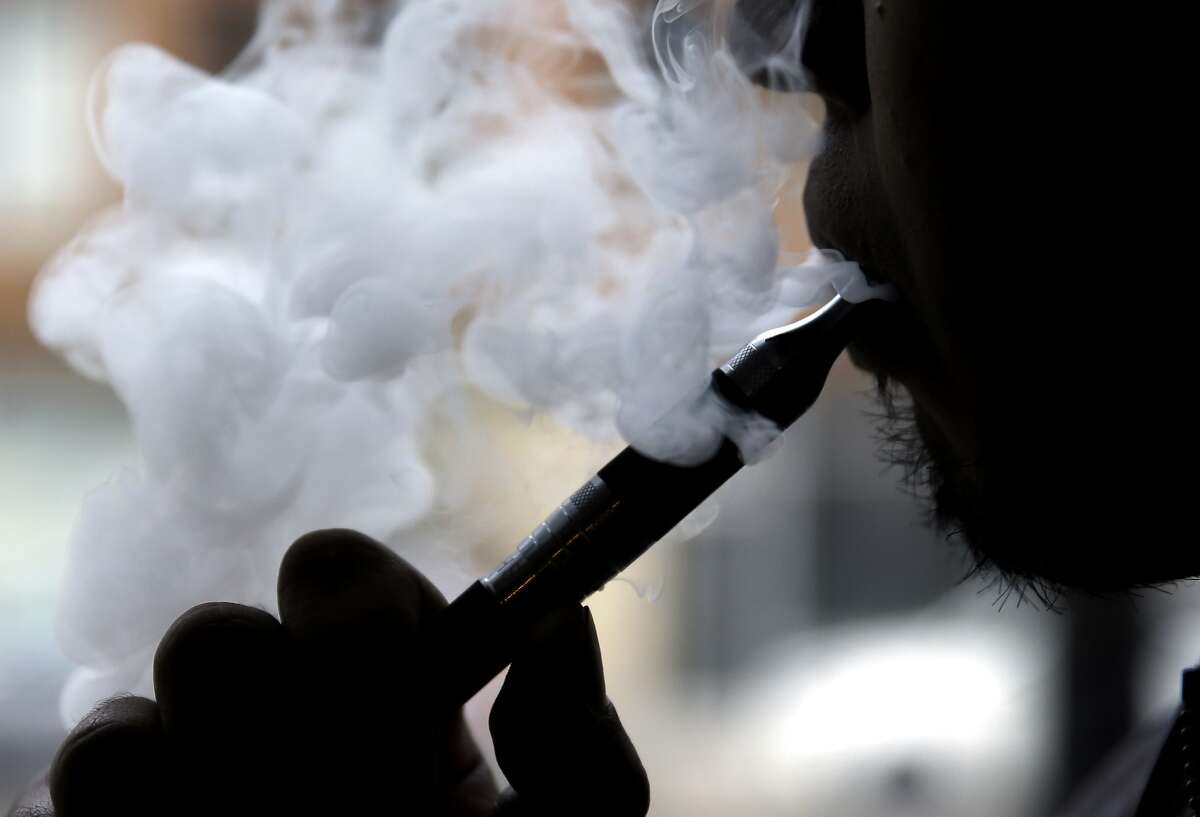 In this April 23, 2014 file photo, a man smokes an electronic cigarette in Chicago. Teen vapers prefer Juul and mint is the #1 flavor among many of them, suggesting a shift after the company’s fruit and dessert flavors were removed from retail stores, new U.S. research suggests. The results are in a pair of studies published Tuesday, Nov. 5, 2019, including a report from the Food and Drug Administration and federal Centers for Disease Control and Prevention indicating that the U.S. teen vaping epidemic shows no signs of slowing down. 