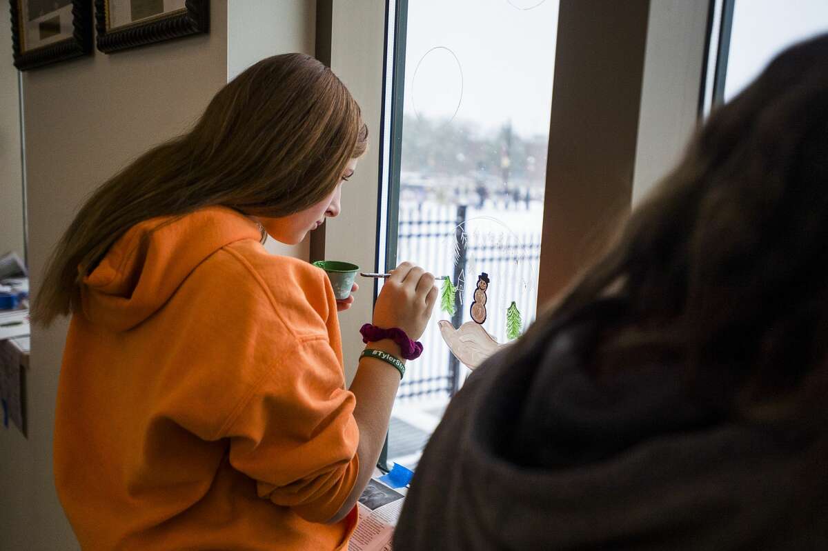 Boys and girls in the Midland County Juvenile Care Center's day treatment program assist the Brush Monkeys painting group in adding winter scenes to windows at the Midland County Courthouse Monday, Nov. 11, 2019. (Katy Kildee/kkildee@mdn.net)