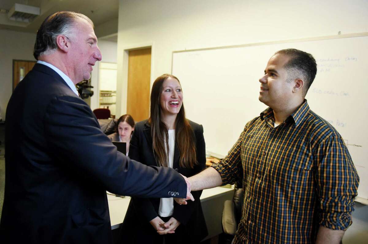 SEFCU CEO Michael Castellana, left, and AlbanyCanCode founder and CEO Annmarie Lanesey, center, talk with Air Force veteran and software programmer Ramon Vazquez, right, on Monday, Nov. 11, 2019, at the UPPmarket office in Troy, N.Y. Vazquez learned computer programming after taking classes through AlbanyCanCode, a Troy nonprofit group that organizes computer programming classes at local community colleges. (Will Waldron/Times Union) Annmarie Lanesey