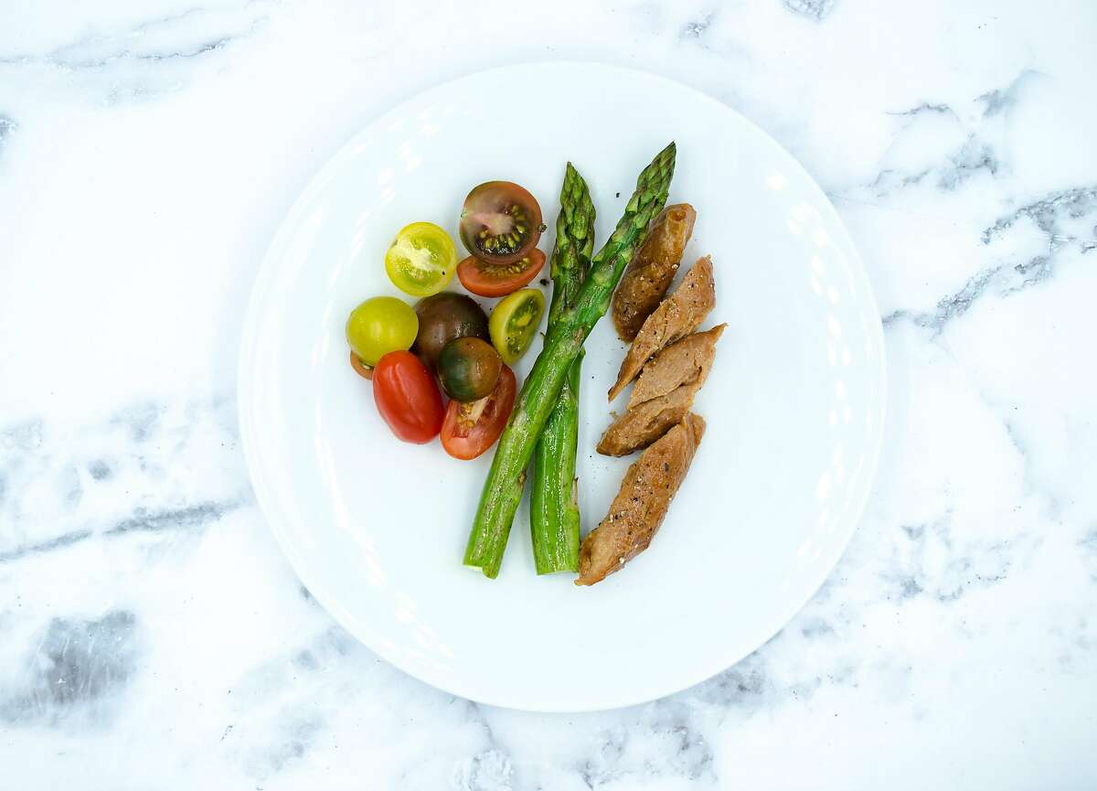 Air-based chicken is served with asparagus and tomatoes. Bay Area company Air Protein makes the meat alternative out of microbes and elements in the air.