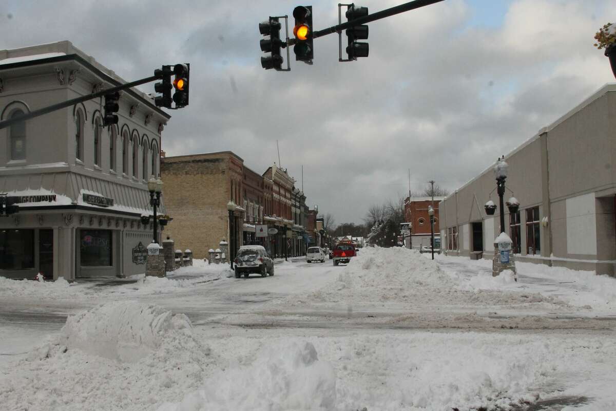City of Manistee DPW workers and business owners worked to clear the downtown area on Tuesday morning after more than a foot of snow fell since Monday afternoon.