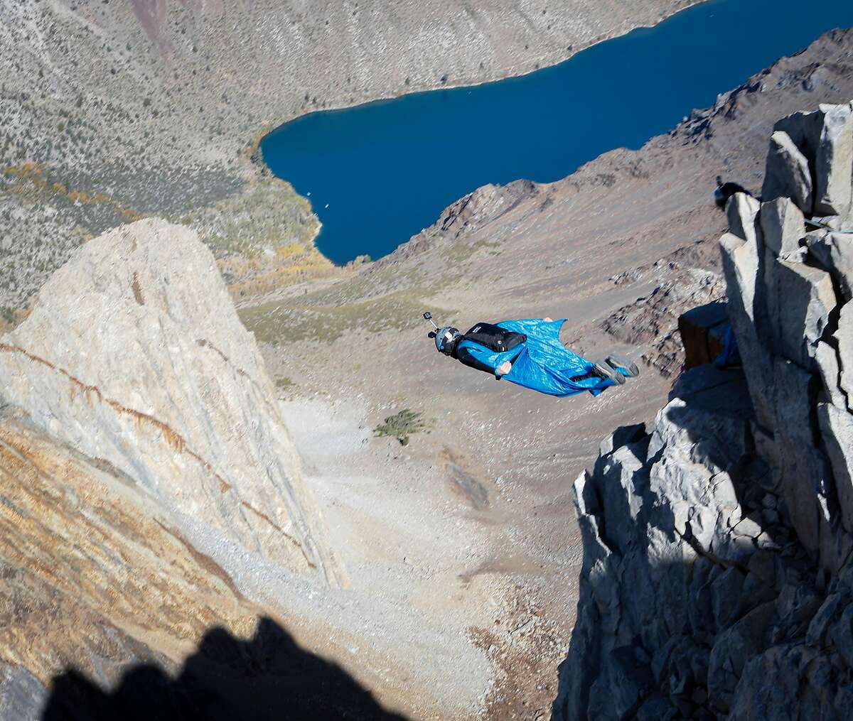 Daniel Ristow jumps from an exit point on Mount Morrison in order to execute a wingsuit base jump on Friday, Oct. 11, 2019 near Convict Lake, which is visible in the background.