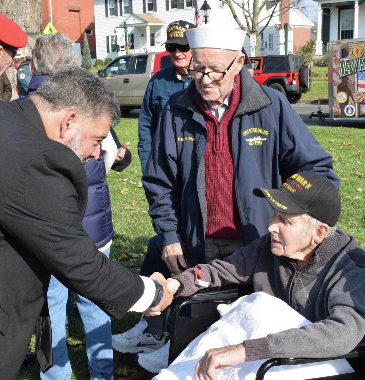 New Milford Mayor Pete Bass, left, thanks World War II veterans Paul Hulton, standing, and Ed Tierney for their service to our country following the ceremony.