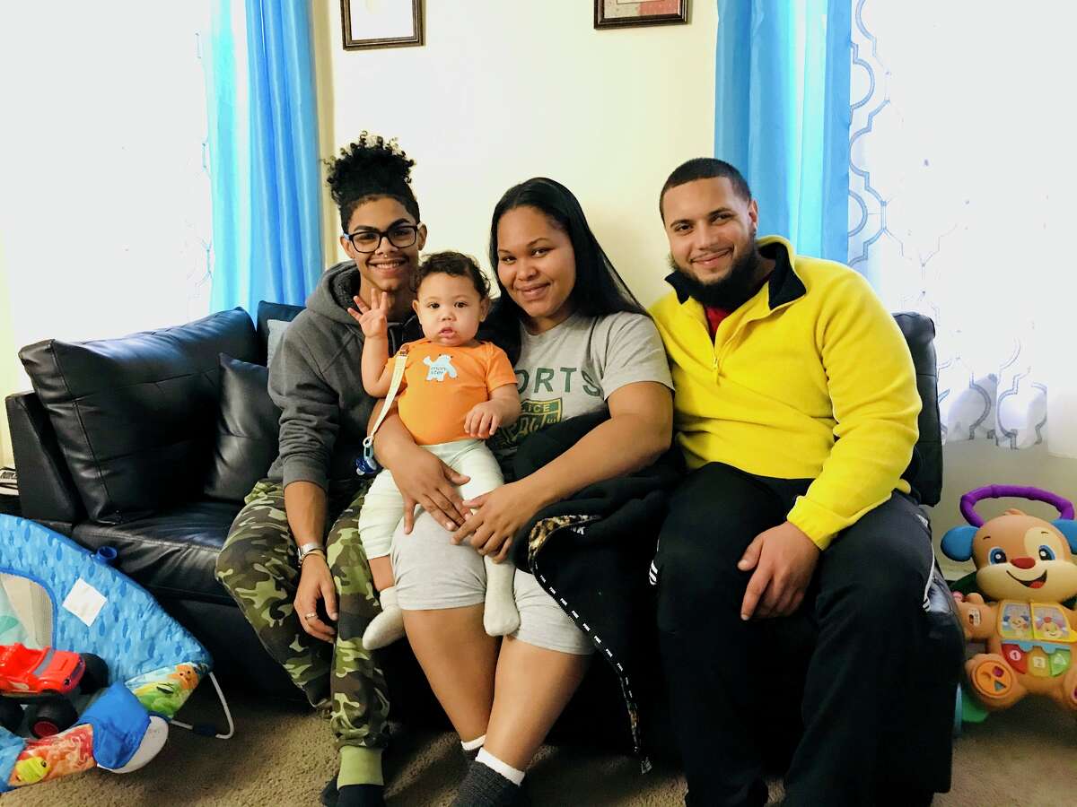 Inside their federally-subsidized two-bedroom apartment in Albany, Jonathan Jimenez, left, his sister Jasmine Almonte and Isaac Espiritusanto pose with baby Jaizeah after nearly being evicted recently