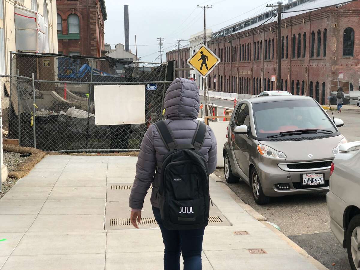 A person wearing a Juul backpack walks towards the e-cigarette maker's headquarters on Pier 70 along the city's waterfront on Dec. 20, 2018 in San Francisco, Calif.