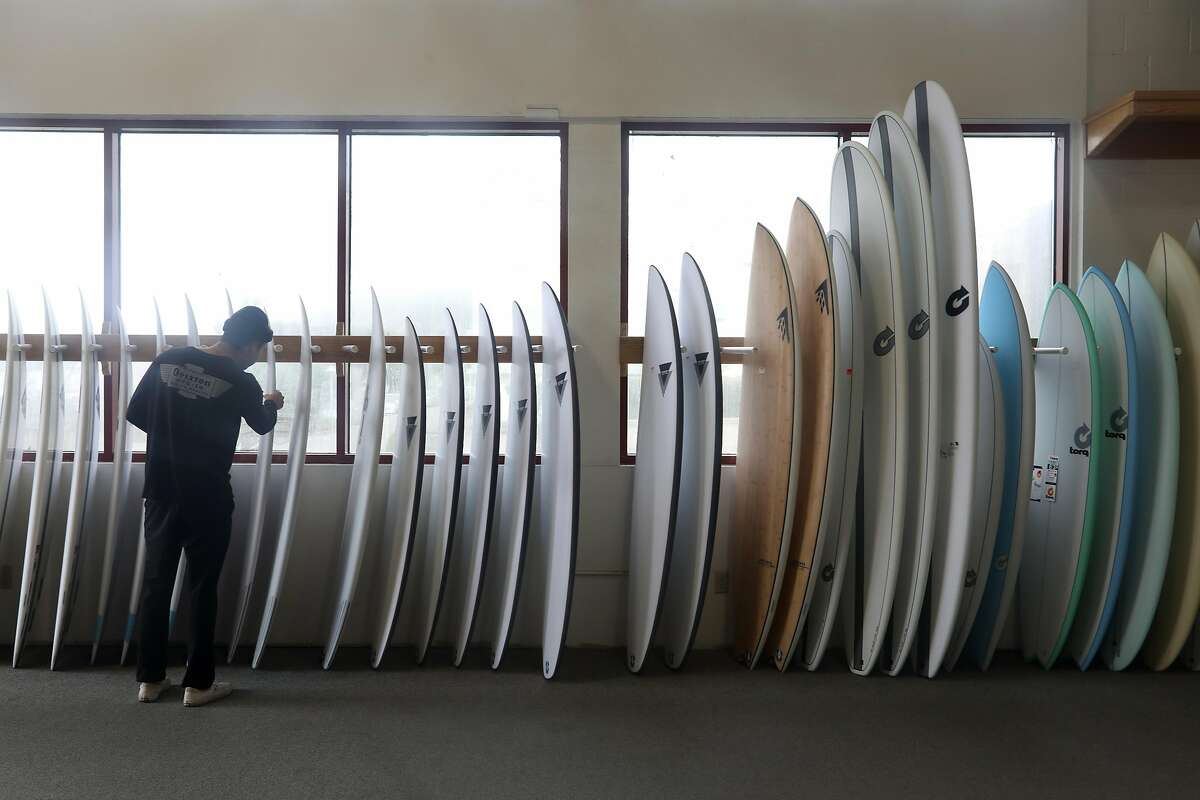 Customer browses through existing boards at Wise Surfboards on Tuesday, Nov. 12, 2019, in San Francisco, Calif.