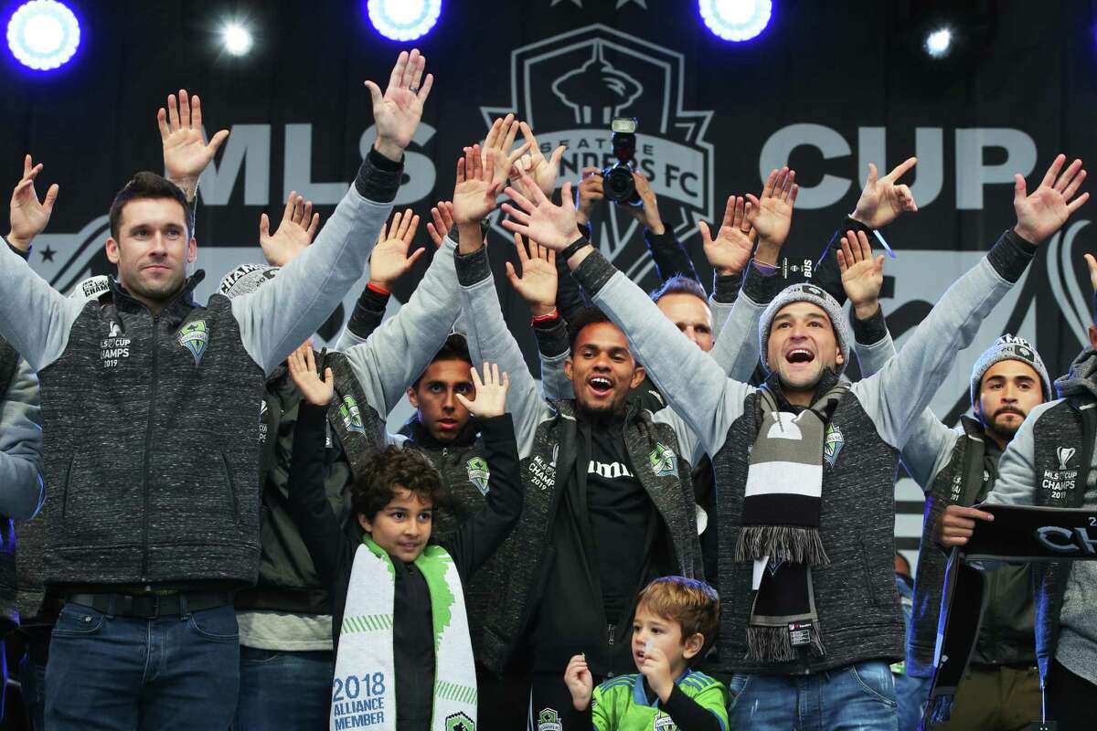 Sounders players raise their hands to the crowd as the city celebrates the their MLS Cup Championship win with a parade from Westlake Park to Seattle Center and a rally, Tuesday, Nov. 12, 2019. The Sounders beat Toronto 3-1 to bring home their second MLS Cup in four years.