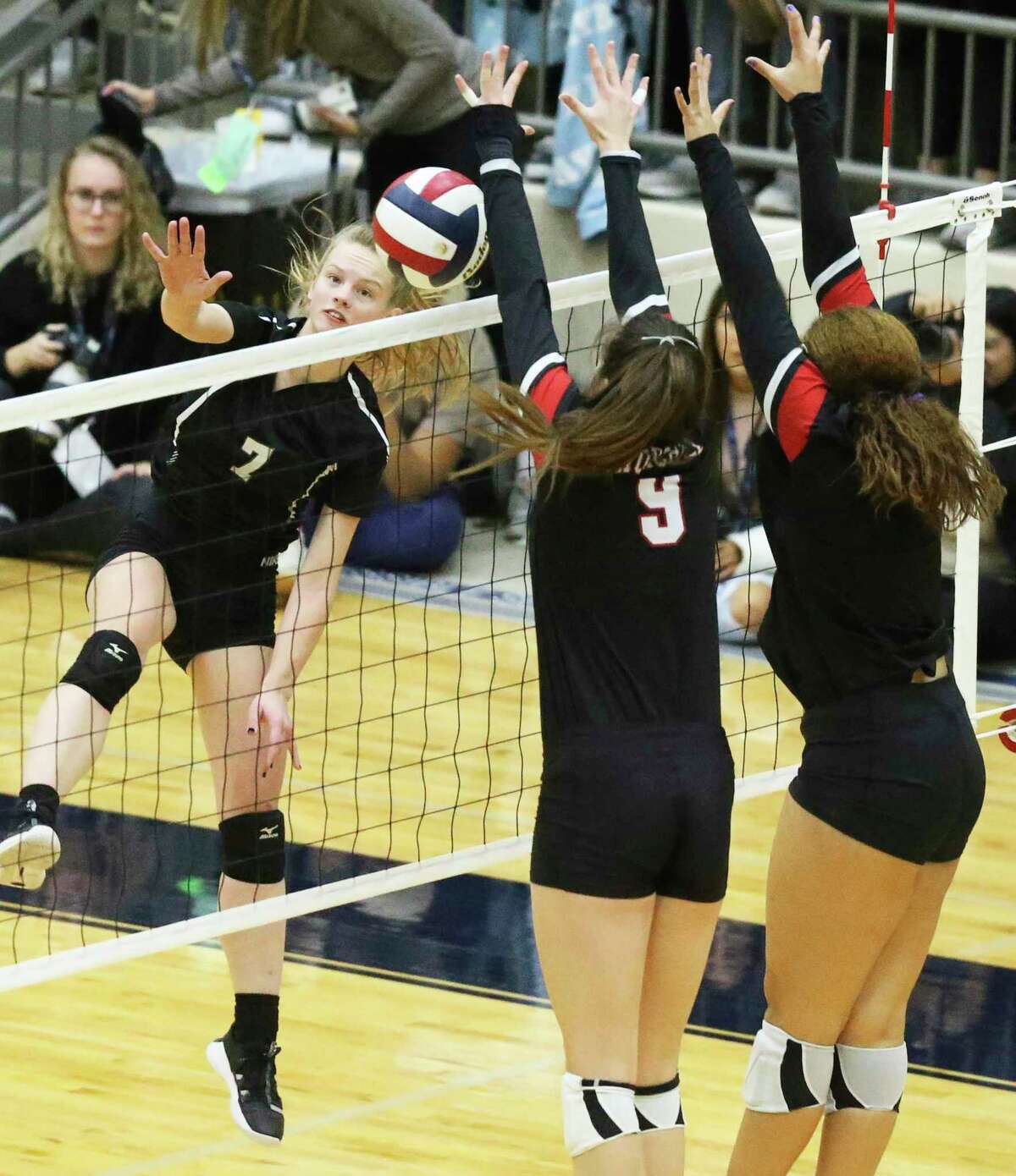 Clark hitter Shadee Briggs gets the ball over defenders as Clark plays Churchill in 6A third round volleyball playoff action at the Alamo Convocation Center on Nov. 12, 2019.