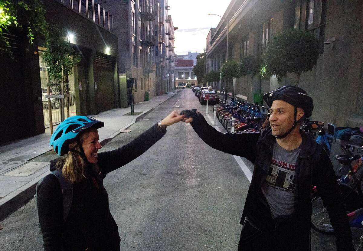 San Francisco Chronicle reporters Heather Knight (left) and Peter Hartlaub fist-bump after dropping off Bay Wheels bikes and finishing the first portion of their journey near Polk and Myrtle streets in San Francisco, Calif. Wednesday, September 4, 2019 as they attempt to traverse San Francisco�s 49-mile Scenic Drive without using a car.