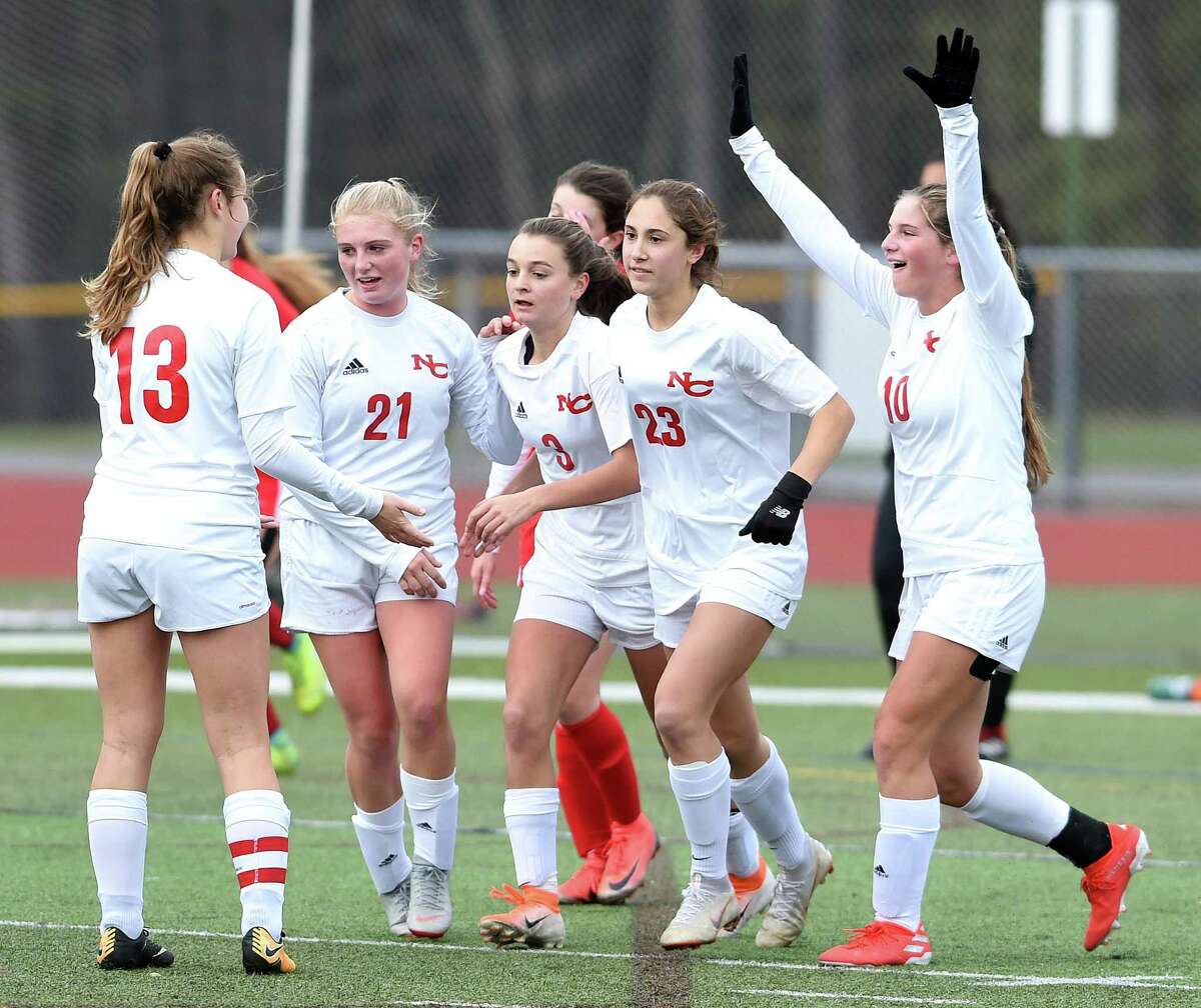 New Canaan celebrates after Dillyn Patten (center) scored against Cheshire on Thursday.