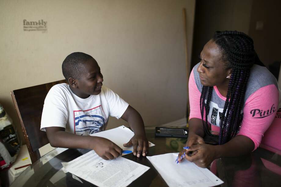 Nicholas, 13, works on his homework with his mother Britany Miller at home in Houston. Davis is an eighth grader at The Lawson Academy. Photo: Marie D. De Jesús/Staff Photographer