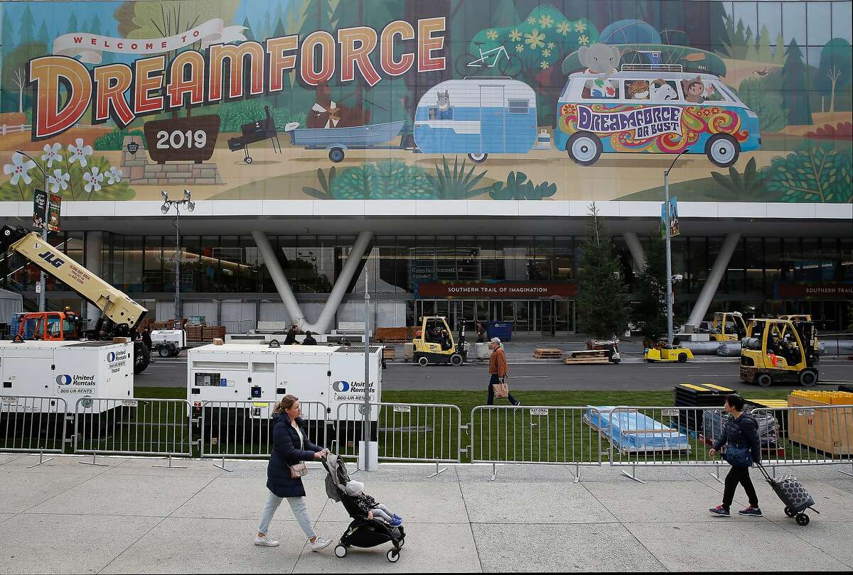 Pedestrians on Howard Street walk past signage for Dreamforce displayed on Moscone Center days before the start of Dreamforce on Friday, November 15, 2019 in San Francisco, Calif.