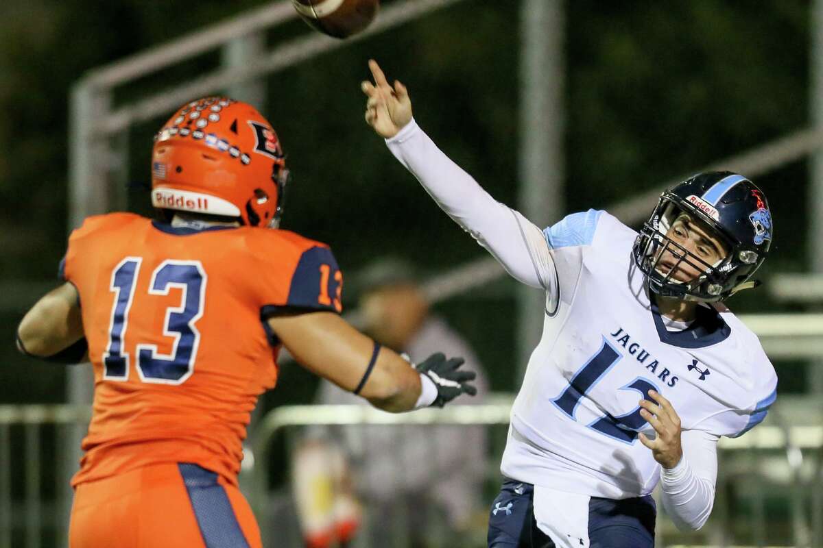 Johnson quarterback Ty Reasoner, right, gets a pass off as Brandeis' Zachary Watson applies pressure in their 6A Division II first round playoff game at Farris Stadium on Friday, Nov. 15, 2019.