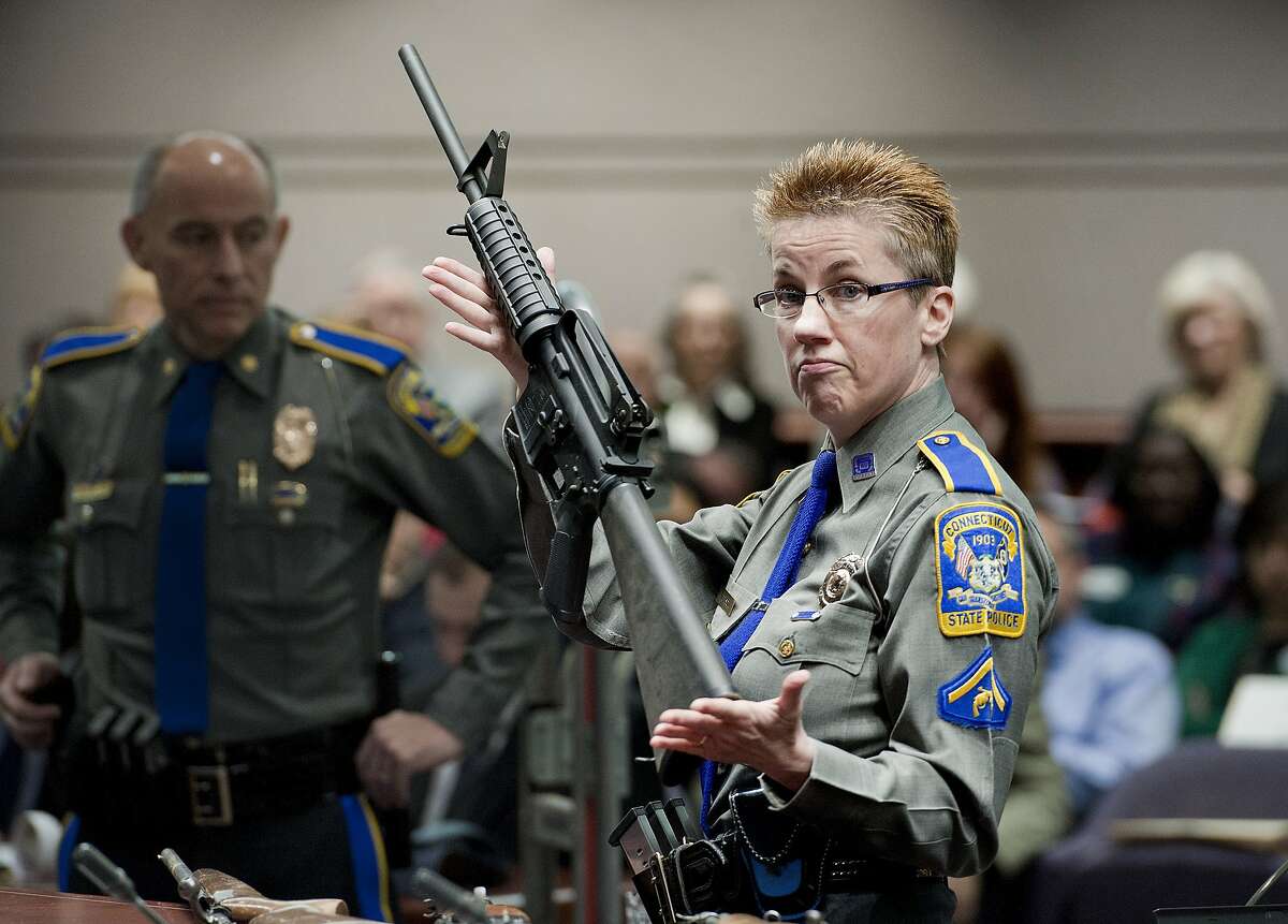 FILE - In this Jan. 28, 2013, file photo, firearms training unit Detective Barbara J. Mattson, of the Connecticut State Police, holds up a Bushmaster AR-15 rifle, the same make and model of gun used by Adam Lanza in the Sandy Hook School shooting, for a demonstration during a hearing of a legislative subcommittee reviewing gun laws, at the Legislative Office Building in Hartford, Conn.