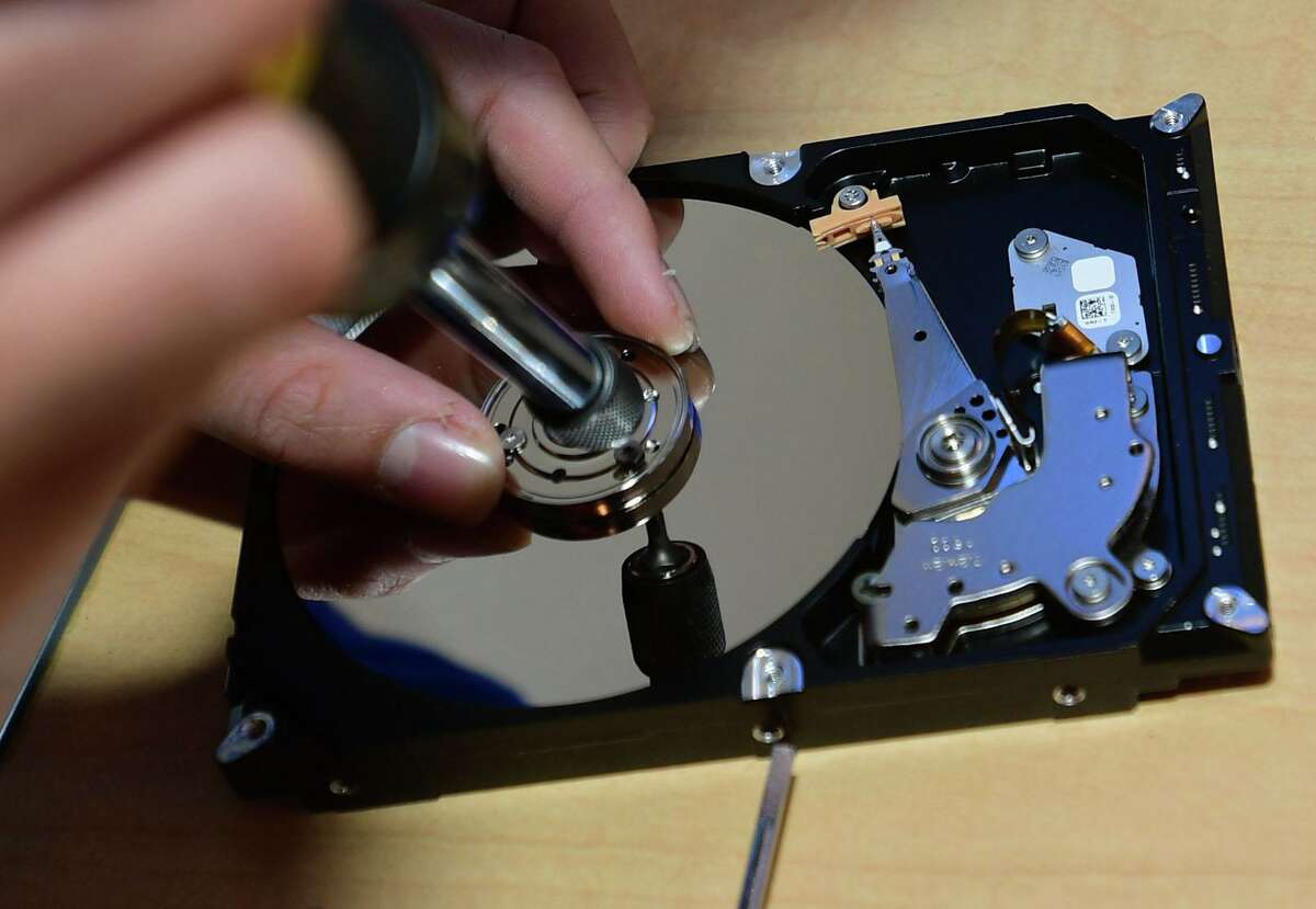 Members of the Wilton Library's robotics team, Singularity Technology, destroy hard drives for residents.