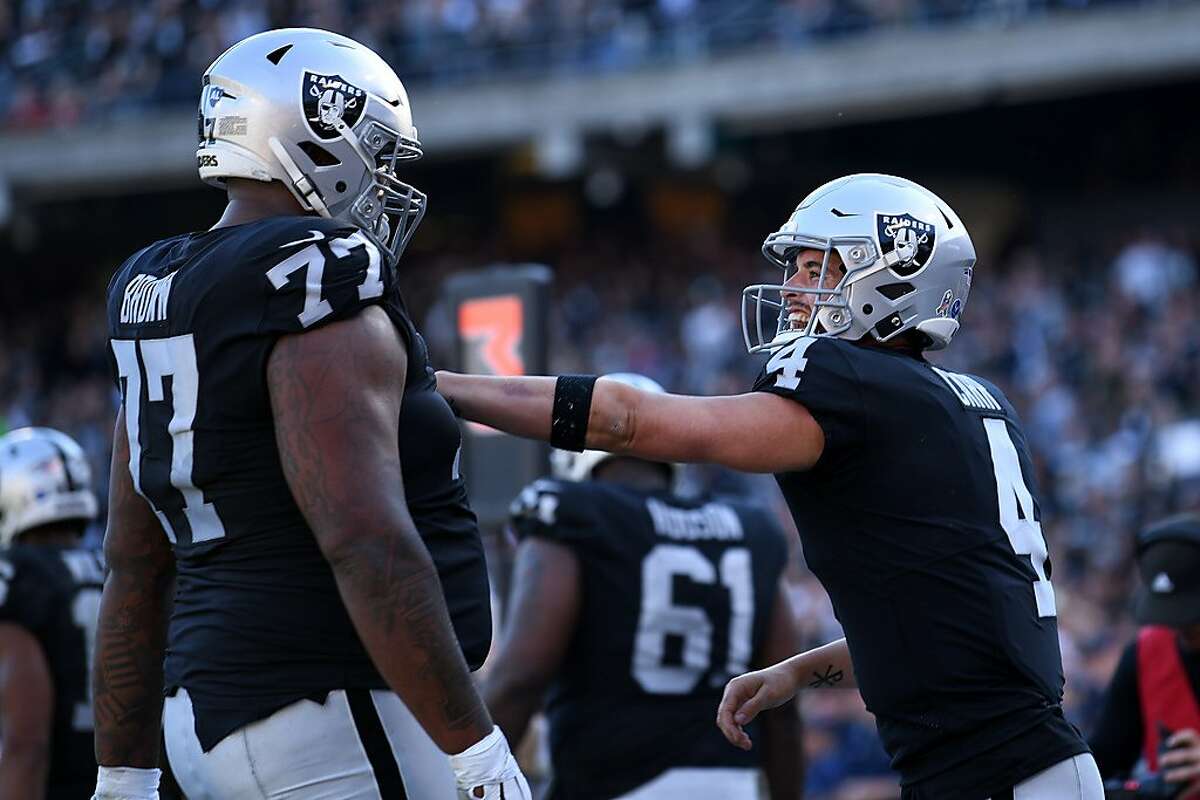 OAKLAND, CALIFORNIA - NOVEMBER 17: Derek Carr #4 of the Oakland Raiders celebrates with Trent Brown #77 after scoring in the second quarter against the Cincinnati Bengals during their NFL game at RingCentral Coliseum on November 17, 2019 in Oakland, California. (Photo by Robert Reiners/Getty Images)