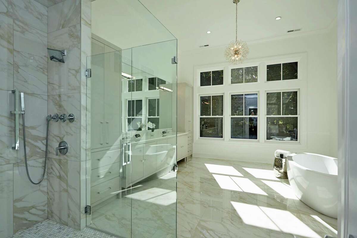 The luxurious marble master bath features a soaking tub, large shower, and double vanity.