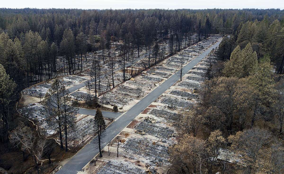 FILE-In this Monday, Dec. 3, 2018, homes are seen leveled by the Camp Fire line the Ridgewood Mobile Home Park retirement community in Paradise, Calif. Northern California authorities have arrested a woman they say scammed $63,100 from a 75-year-old who lost a home in the wildfire in 2018. The Butte County Sheriff's Office announced Tuesday, Nov. 5, 2019, the arrest of 29-year-old Brenda Rose Asbury for elder abuse, embezzlement and grand theft. (AP Photo/Noah Berger)