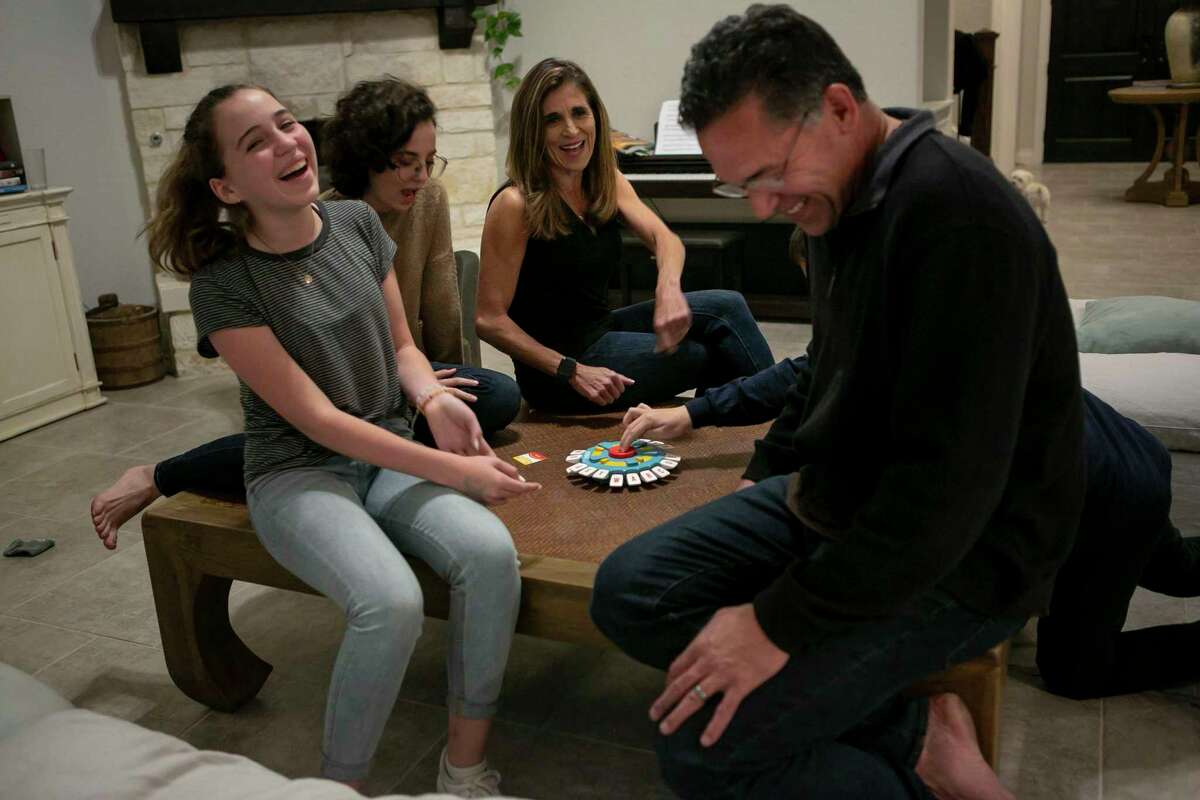 Laughter erupts at the end of a round of a game in the Michell family home.