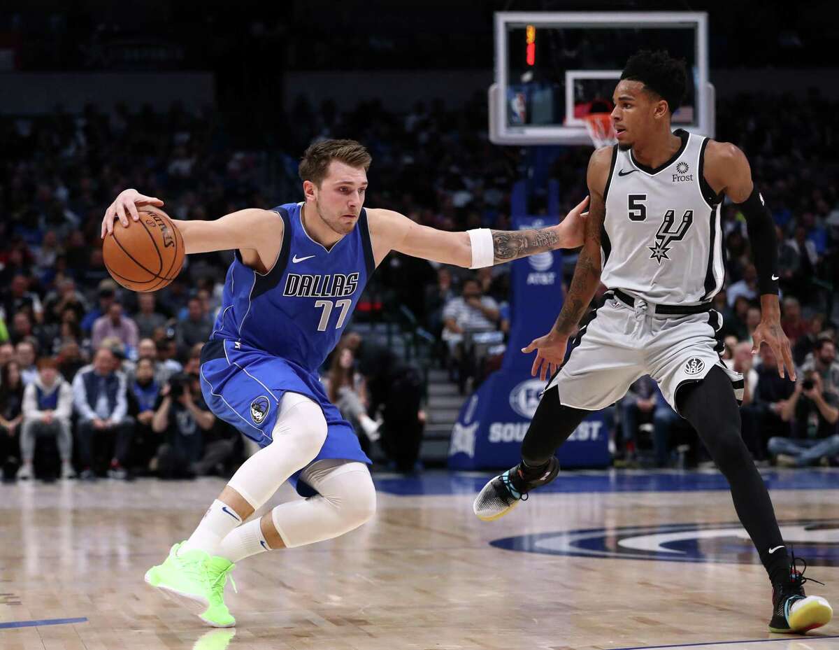 DALLAS, TEXAS - NOVEMBER 18: Luka Doncic #77 of the Dallas Mavericks dribbles the ball against Dejounte Murray #5 of the San Antonio Spurs in the first half at American Airlines Center on November 18, 2019 in Dallas, Texas. NOTE TO USER: User expressly acknowledges and agrees that, by downloading and or using this photograph, User is consenting to the terms and conditions of the Getty Images License Agreement. (Photo by Ronald Martinez/Getty Images)