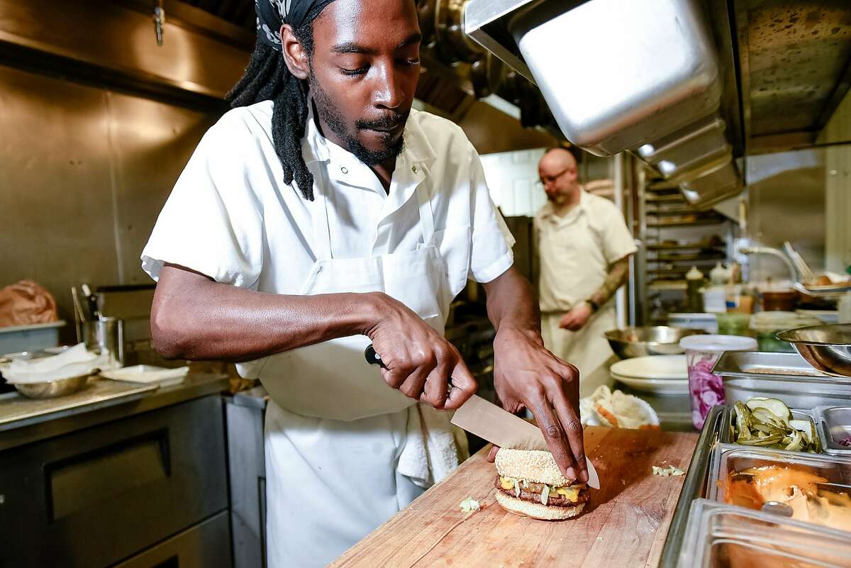 Chef de partie Kenny McLeod cuts an Impossible Burger order in the kitchen at Violet's restaurant in San Francisco, Calif., on July 21st, 2019. Impossible Foods is distributing Impossible Burgers to independent restaurants again after a two-month dry spell, which coincided with its expansion to Burger Kings nationwide.
