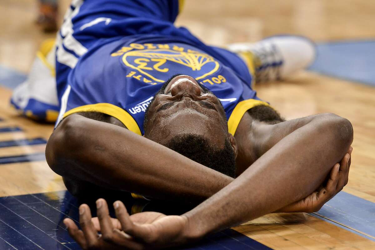 Golden State Warriors forward Draymond Green lies on the court after falling during the second half of the team's NBA basketball game against the Memphis Grizzlies on Tuesday, Nov. 19, 2019, in Memphis, Tenn. (AP Photo/Brandon Dill)