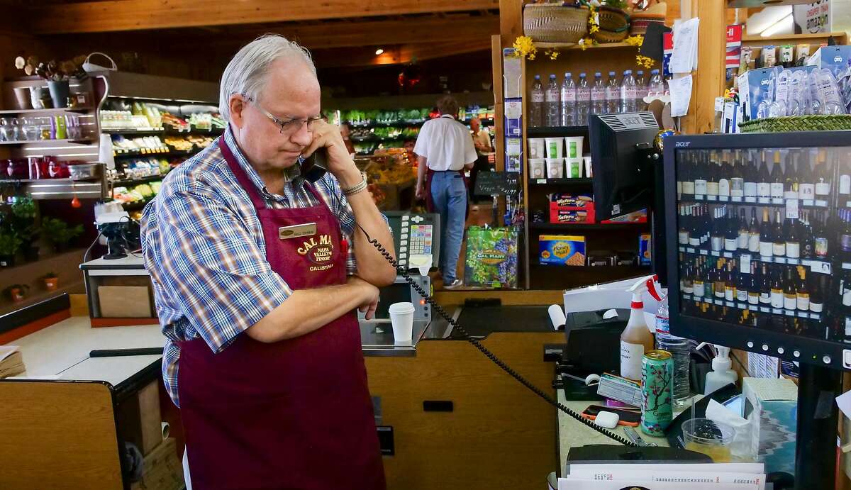 Cal Mart owner Bill Shaw helps customer on the phone, Thursday Aug. 29, 2019, in downtown Calistoga, Ca. He is prepared to rent a generator if need for a PG&E shutdown.