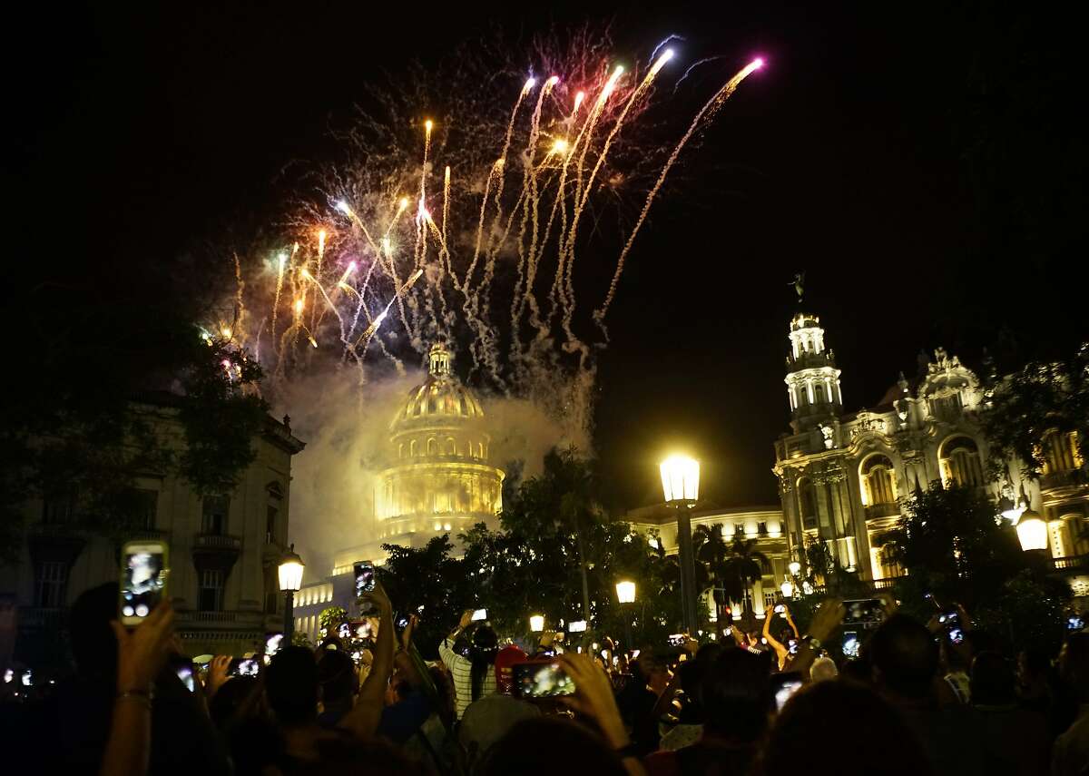 People take pictures of the fireworks at the Capitol during a gala as part of the celebration of the 500 years of the city in Havana, Cuba, Saturday, Nov. 16, 2019. Havana celebrates its 500th anniversary, a milestone event that has sparked reflection in the country, as it faces increasingly tense relations with the U.S. and serious economic challenges. (AP Photo/Ramon Espinosa)