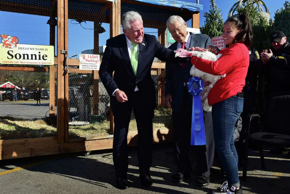 Norwalk Mayor Harry Rilling joins Stew Leonard Sr. to pardon Sonnie the turkey with the help of employee Evelin Jaimes as Stew Leonard's Turkey Brigade hands out Thanksgiving turkeys to residents in need, soup kitchen reps, homeless shelters and other charities via human assembly line Thursday, November 21, 2019, at the store in Norwalk, Conn. Over 3,000 turkeys were distributed.