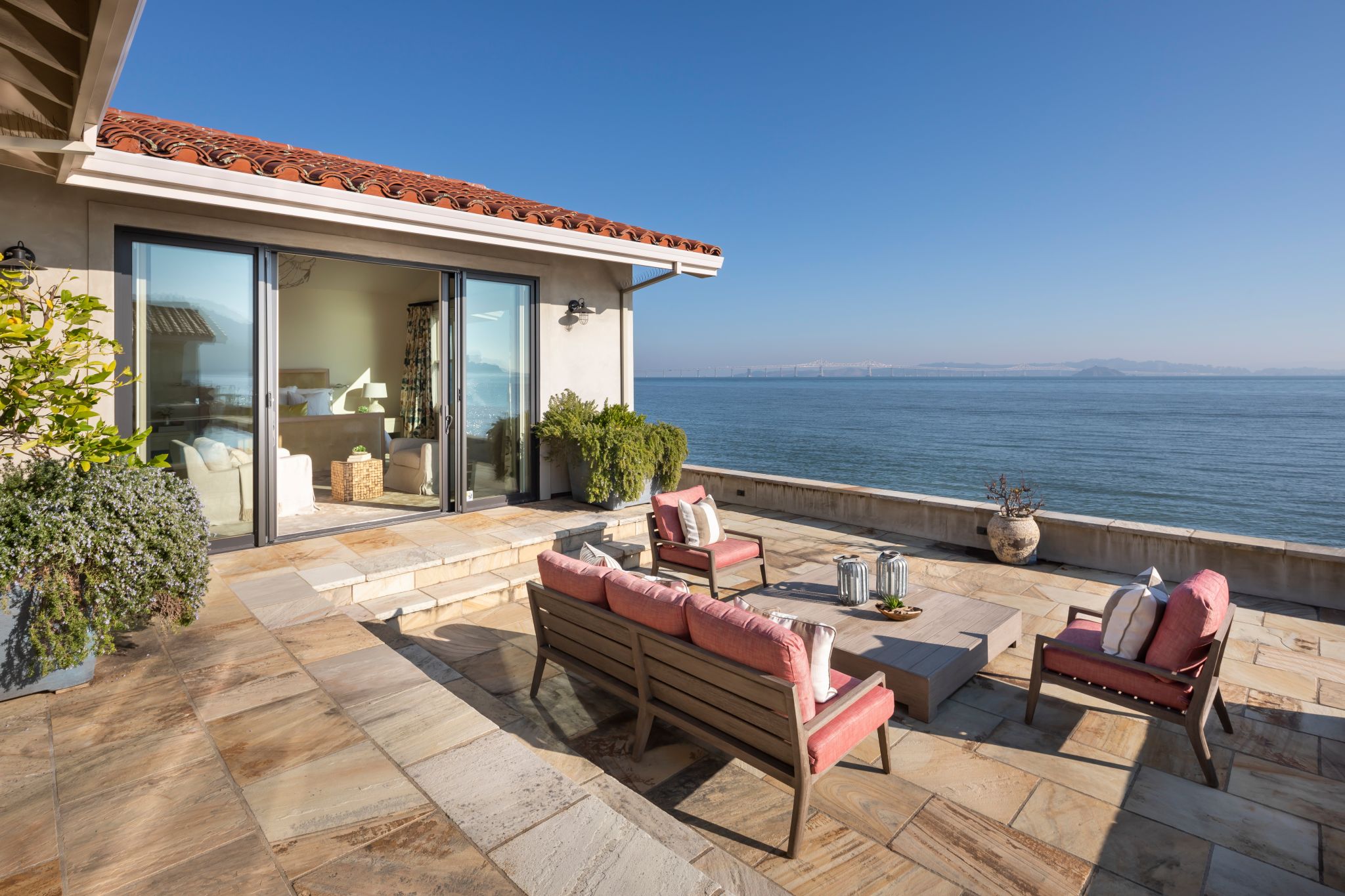 The outdoor patio features a pool and hot tub that overlook the Bay.