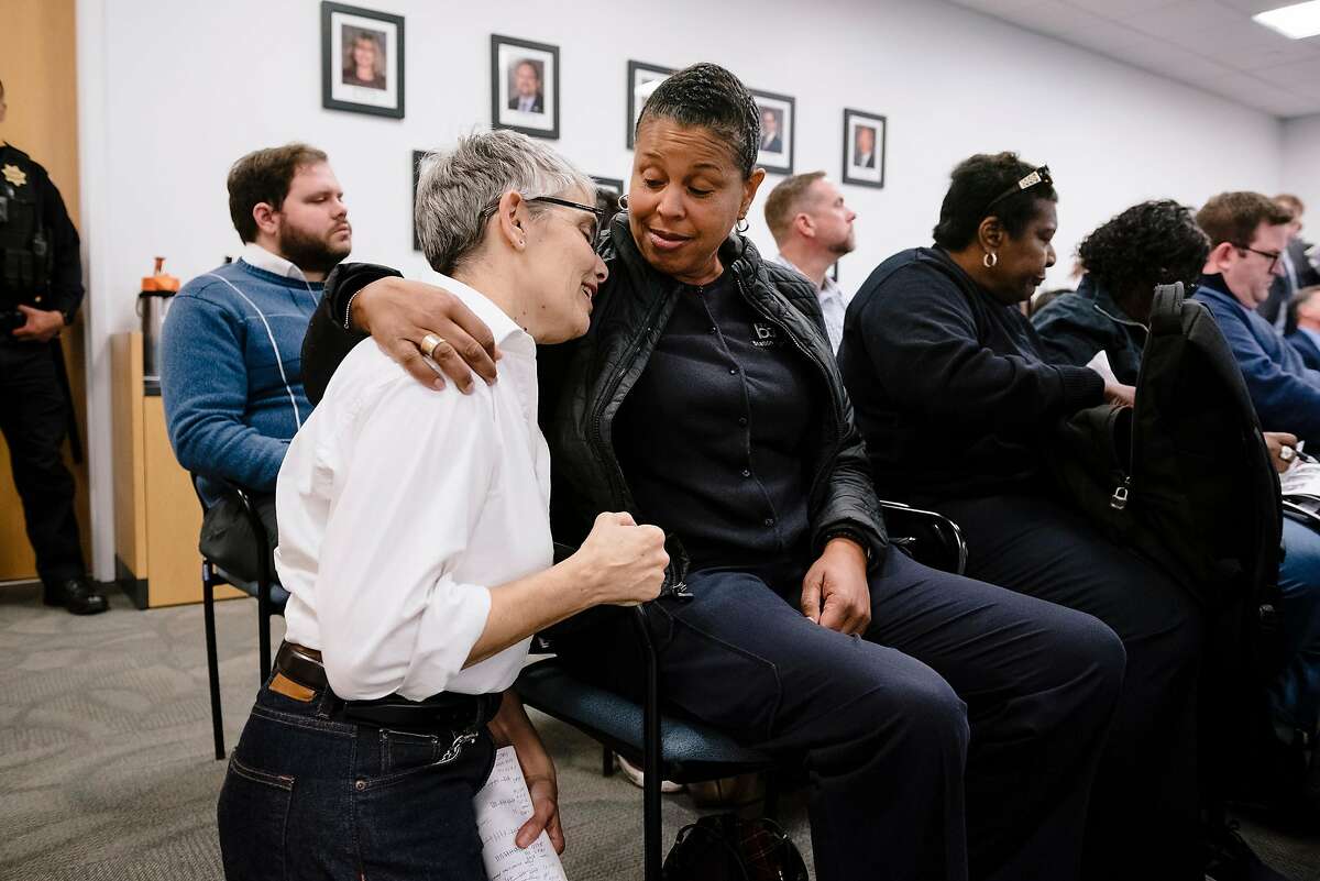 BART station agent Suzanne Gamble, left, gets a hug and advice from South Hayward station agent and station agent representative Stephanie Barnes during a BART meeting in Oakland, California, Monday, November 21, 2019.