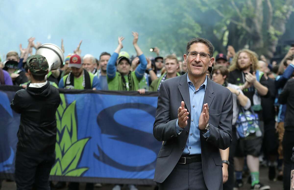 FILE - In this June 30, 2018, file photo, Seattle Sounders owner Adrian Hanauer, right, takes part in the traditional March to the Match before an MLS soccer match in Seattle. Seattle will host the MLS Cup soccer match Sunday, Nov. 10, 2019, as the Sounders face Toronto FC at CenturyLink Field. (AP Photo/Ted S. Warren, File)