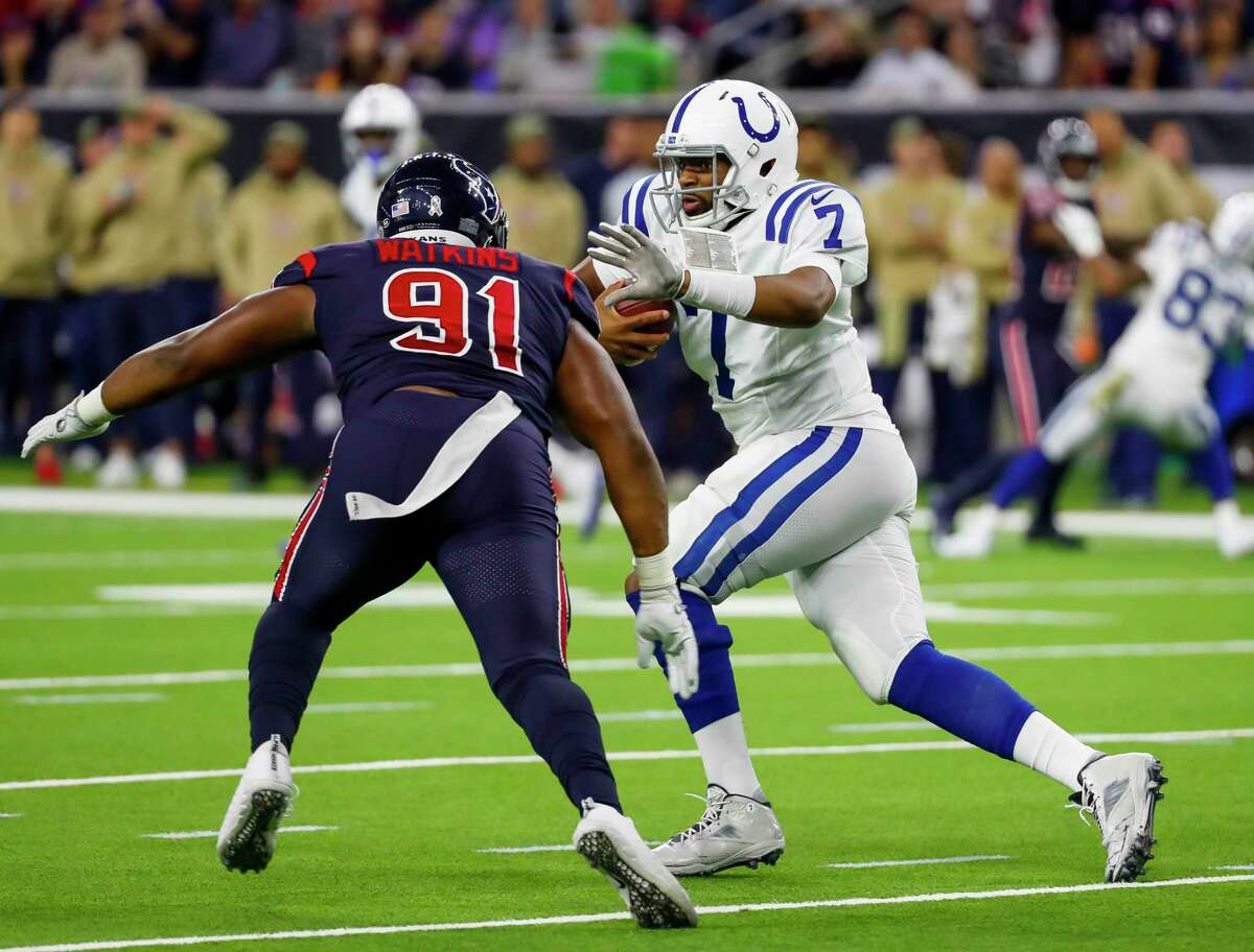 Indianapolis Colts quarterback Jacoby Brissett (7) tries to avoid Houston Texans defensive end Carlos Watkins (91) during the second quarter of an NFL football game at NRG Stadium on Thursday, Nov. 21, 2019, in Houston.