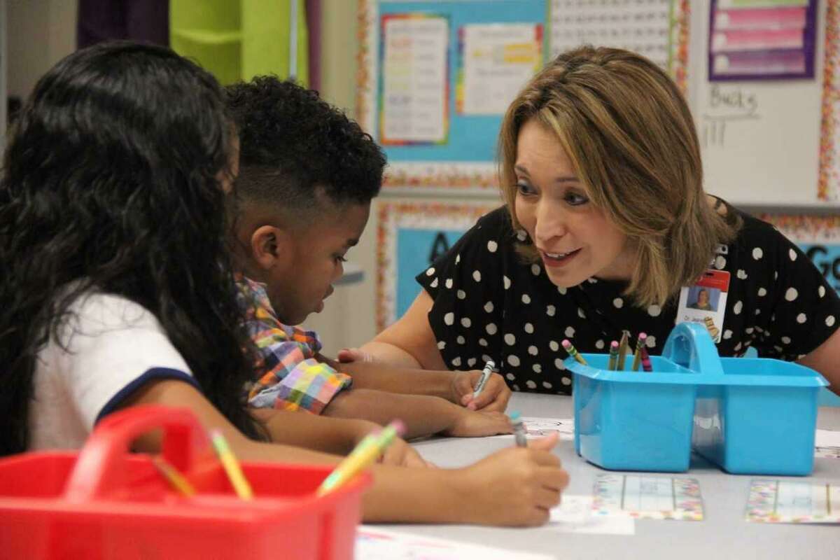 Judson Superintendent Jeanette Ball talks with two elementary school children Aug. 20 on the first day of school.
