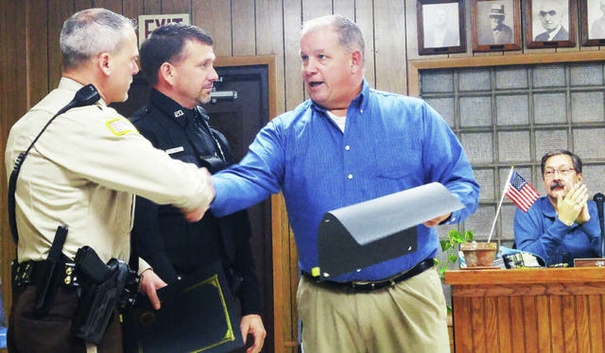 Grafton Mayor Rick Eberlin, right, presents certificates of appreciation to Jersey County Deputy Justin Decker, left, and Grafton Police Officer Mike Angel during the village’s Nov 19 council meeting. The two officers were honored for their outstanding performance during a Grafton fire where they quickly evacuated residents and minimized property loss.