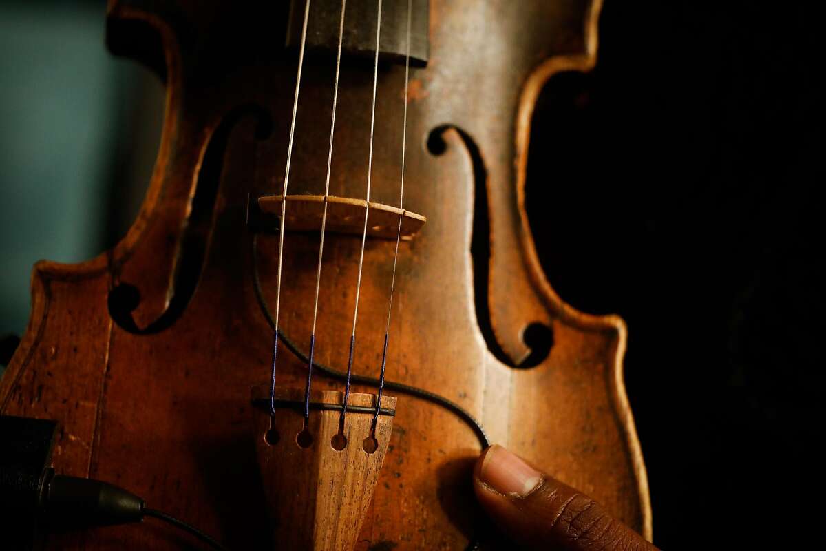 Violinist Kippy Marks holds onto his violin Izabella at his home in San Francisco, California, on Wednesday, Nov. 20, 2019.