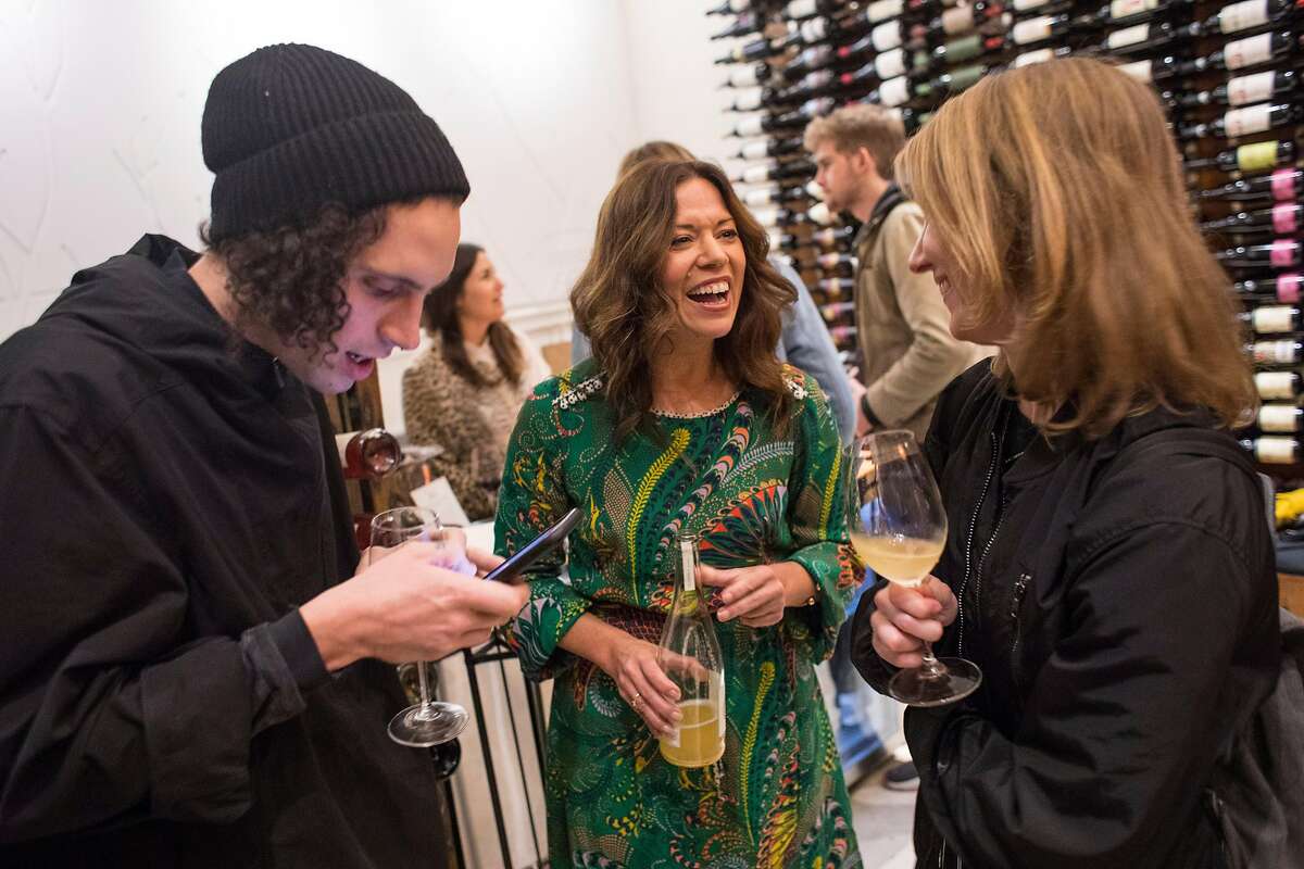 Owner of Biondivino wine shop Ceri Smith, center, pours a bottle-fermented sparkling wine for Marco Tarantelli, left, and Rachel Spackman during a wine tasting at the shop on Tuesday, Nov. 19, 2019 in San Francisco, Calif.