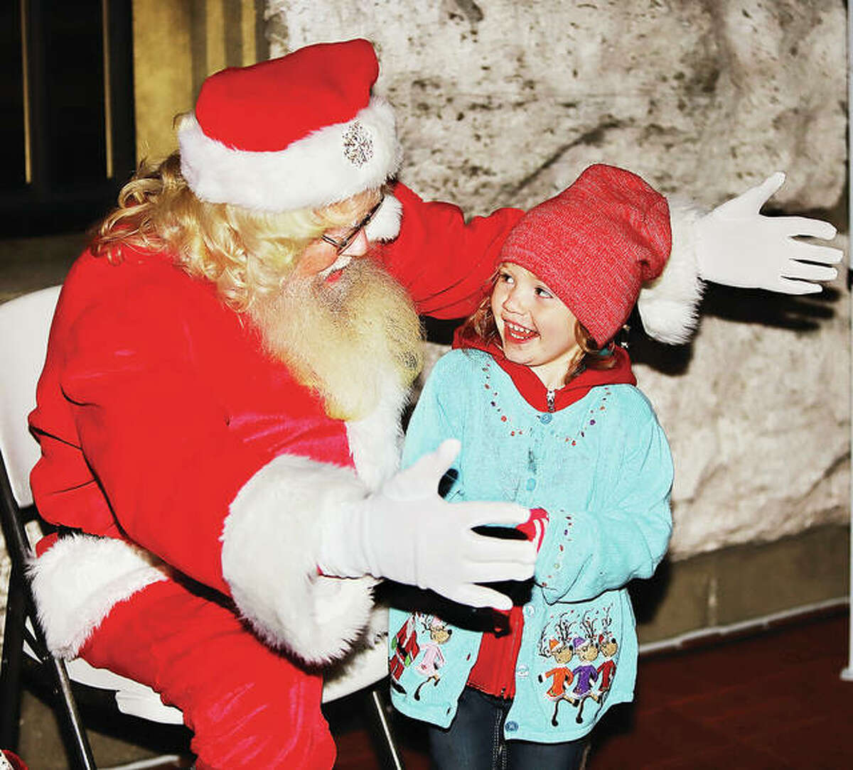 Santa Claus holds out his arms to give a big welcome and hug to Alayna Ahlin, 3, of Jerseyville, as she meets him Friday night at the 25th Annual Community Tree Lighting in Lincoln-Douglas Square in Alton. Several hundred people showed up to see Santa, listen to Christmas carols and see the downtown tree lit.