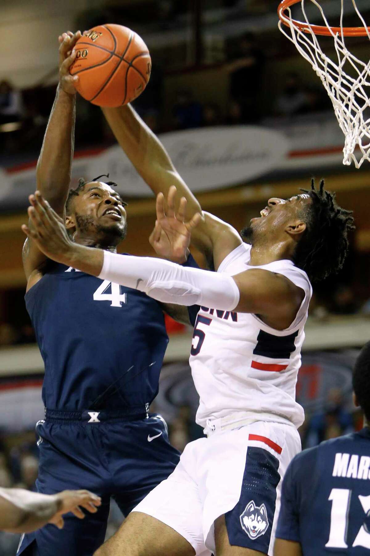 Xavier's Tyrique Jones, at left, goes up for a shot against the defense of Connecticut's Isaiah Whaley in the first half of an NCAA college basketball game during the Charleston Classic Friday, Nov. 22, 2019, in Charleston, SC. (AP Photo/Mic Smith)