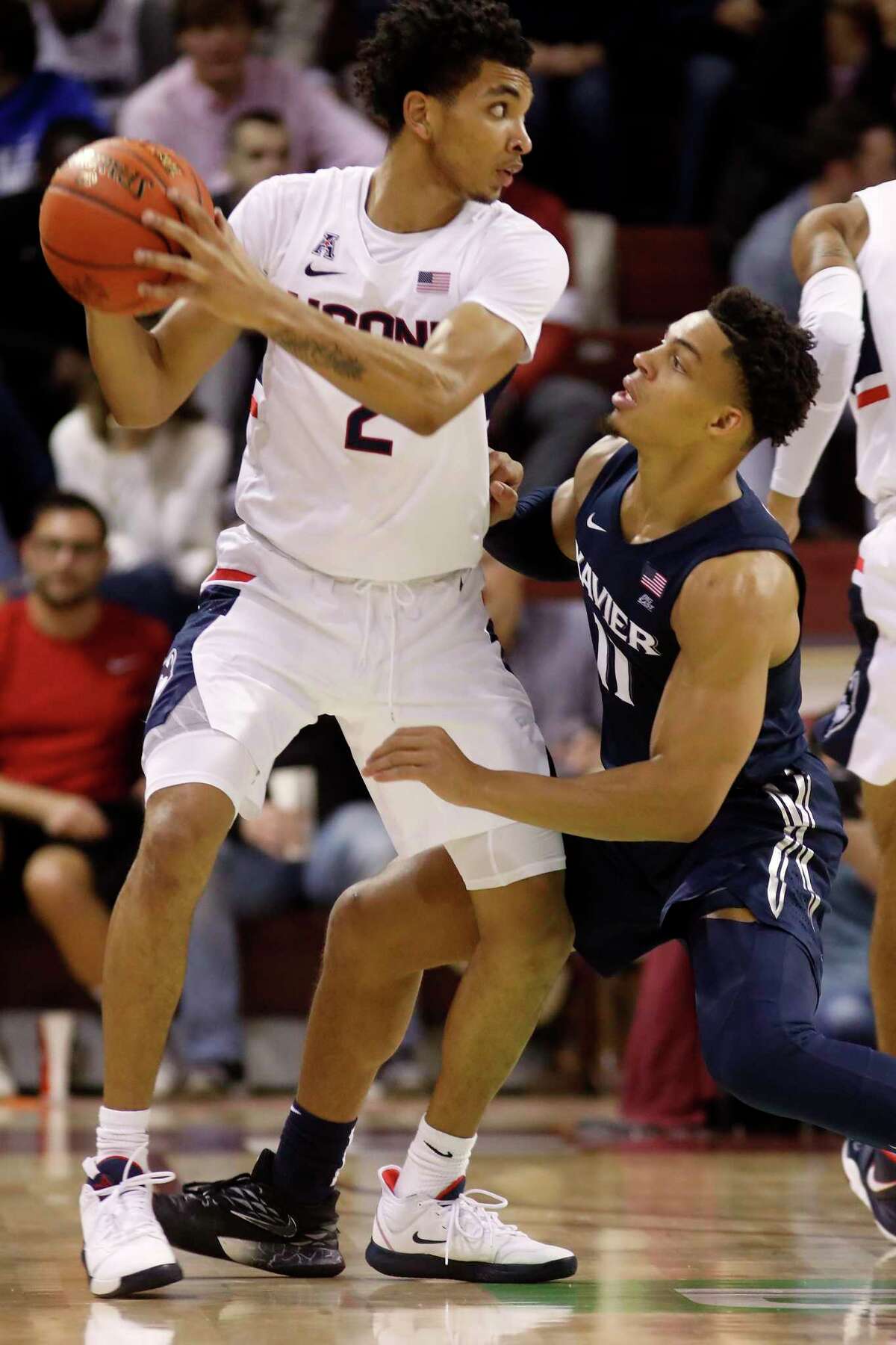 UConn’s James Bouknight, left, fights off the defense of Xavier’s Bryce Moore on Friday at the Charleston Classic.