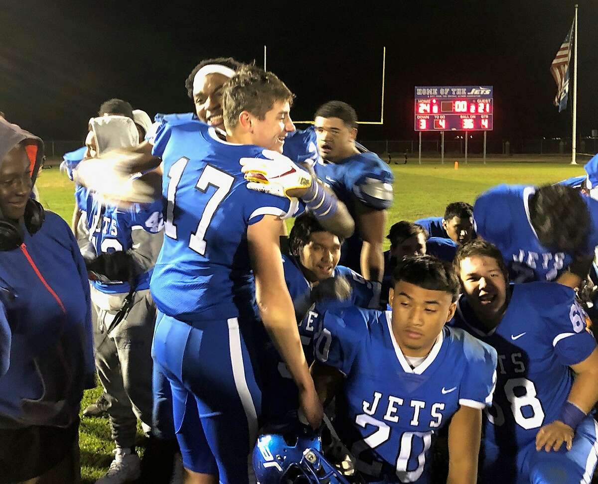 Encinal placekicker John Brindley (17) is hugged by teammate Vincent Nunley after Brindley’s 23-yard field goal at the end of regulation lifted the Jets to a 24-21 win.