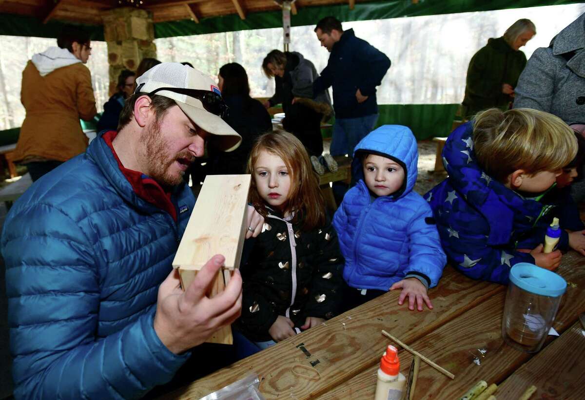 Wilton residents Brice Chaney and his kids, Piper, 5, and Declan, 2, build bee houses during the Woodcock Nature Center Mason Bee Workshop.
