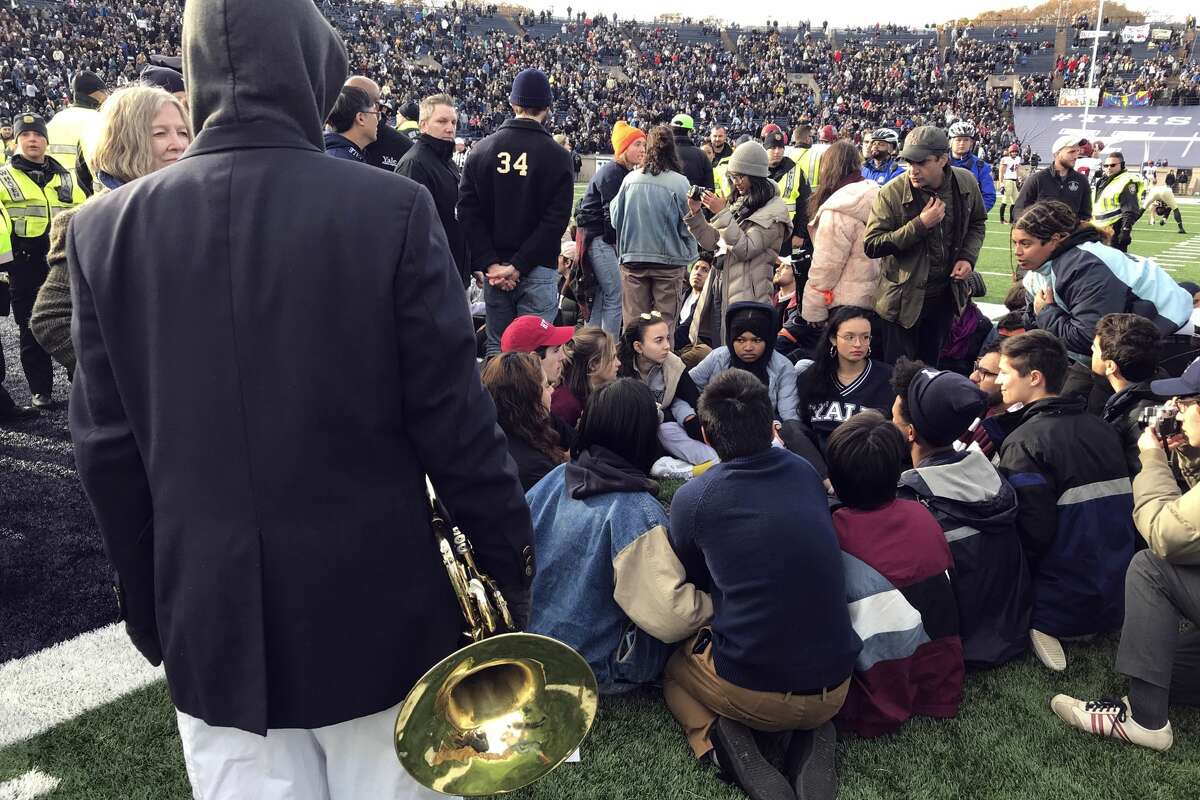 Demonstrators stage a protest on the field at the Yale Bowl disrupting the start of the second half of an NCAA college football game between Harvard and Yale, Saturday, Nov. 23, 2019, in in New Haven, Conn. (AP Photo/Jimmy Golen)