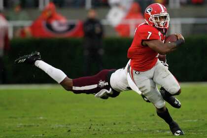 El corredor de Georgia D'Andre Swift (7) mueve la pelota durante la primera mitad de un partido de fútbol americano universitario de la NCAA contra Texas A&M, el sábado 23 de noviembre de 2019 en Atenas, Georgia (Joshua L. Jones / Athens Banner-Herald a través de AP)