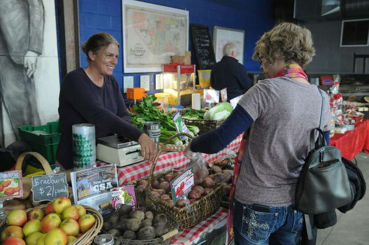 Amy Cloud of Three Rivers Community Farm at Elsah sells produce during Saturday’s inaugural Holiday Cheer Market at Old Bakery Beer Co. in Alton. The event featured community-based vendors offering locally made, grown or crafted items.