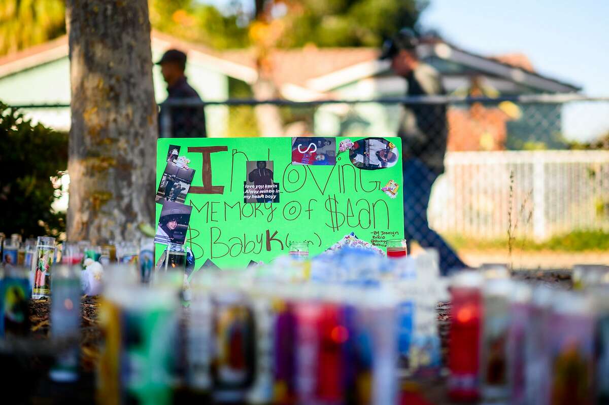 People pass a memorial for two boys, age 11 and 14, killed in the Searles Elementary School parking lot in Union City, Calif., on Sunday. Nov. 24, 2019.