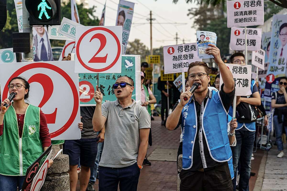 Supporters for Junius Kwan-yiu Ho, right side, and supporters for his opponent, Democratic Party challenger Lo Chun-yuin, left side, campaign in front of each other in the Tuen Mun district of Hong Kong, on Sunday, Nov. 24, 2019. Officials are calling the voter turnout numbers the biggest in the city's history. (Marcus Yam/Los Angeles Times/TNS)