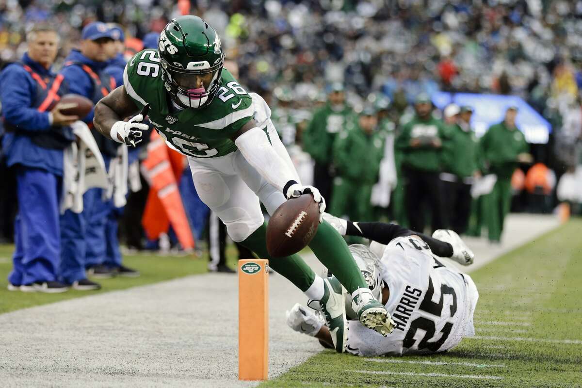 New York Jets running back Le'Veon Bell (26) reaches toward the end zone as he is forced out bounds by Oakland Raiders' Erik Harris (25) during the second half of an NFL football game Sunday, Nov. 24, 2019, in East Rutherford, N.J. (AP Photo/Adam Hunger)