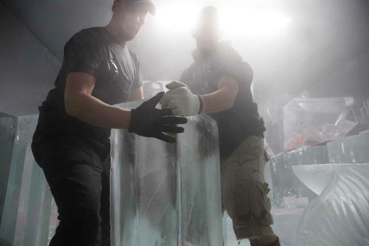 DLG Ice Factory ice carvers Don Lowing, left, and Christopher "Bull Bad Company" Barnes moving ice blocks to prepare an order for the Frostival at Discovery Green, which they are producing the Houston skyline, on Thursday, Nov. 21, 2019, in Houston. The company prepares as many as 100 blocks of ice for holiday events, and starting December 1, they’re booked for at least one event a day.